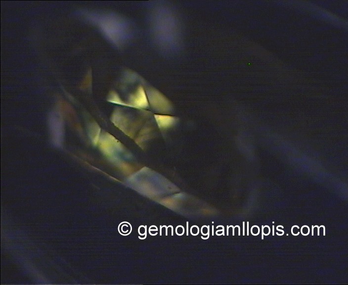 Colores naranjas, amarillos y verdosos producidos por interferencia de la uz provocada por tensiones internas. El diamante está situado entre polarizadores cruzados.