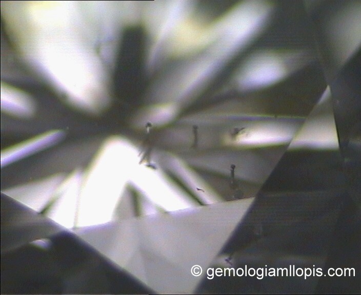 Tres orificios de láser en la superficie del diamante. Luz reflejada, 20X.
